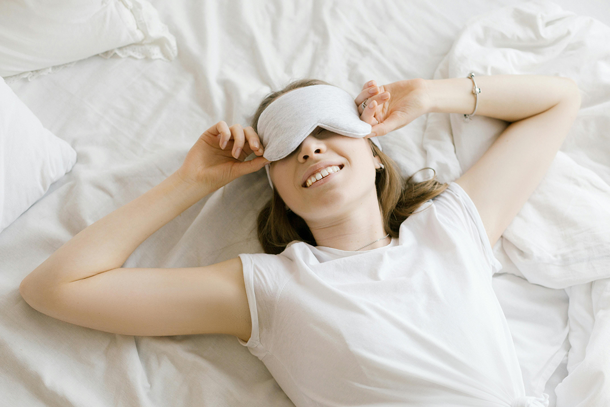 alm bedroom with soft lamp light representing a simple evening routine for better sleep