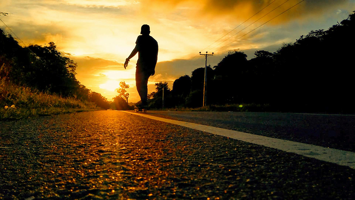 A person walking along a peaceful path at sunrise, symbolizing letting go and moving forward